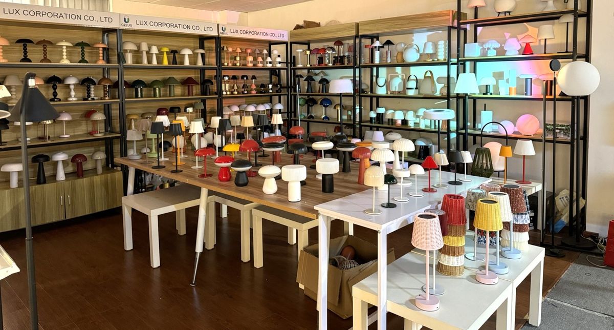 LUX showroom overview - shelves and tables displaying diverse lighting collection including table lamps, floor lamps and pendant lights